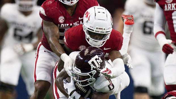 Arkansas Razorbacks defensive back Lorando Johnson tackles Texas A&M Aggies wide receiver Ainias Smith during the first half at AT&T Stadium.